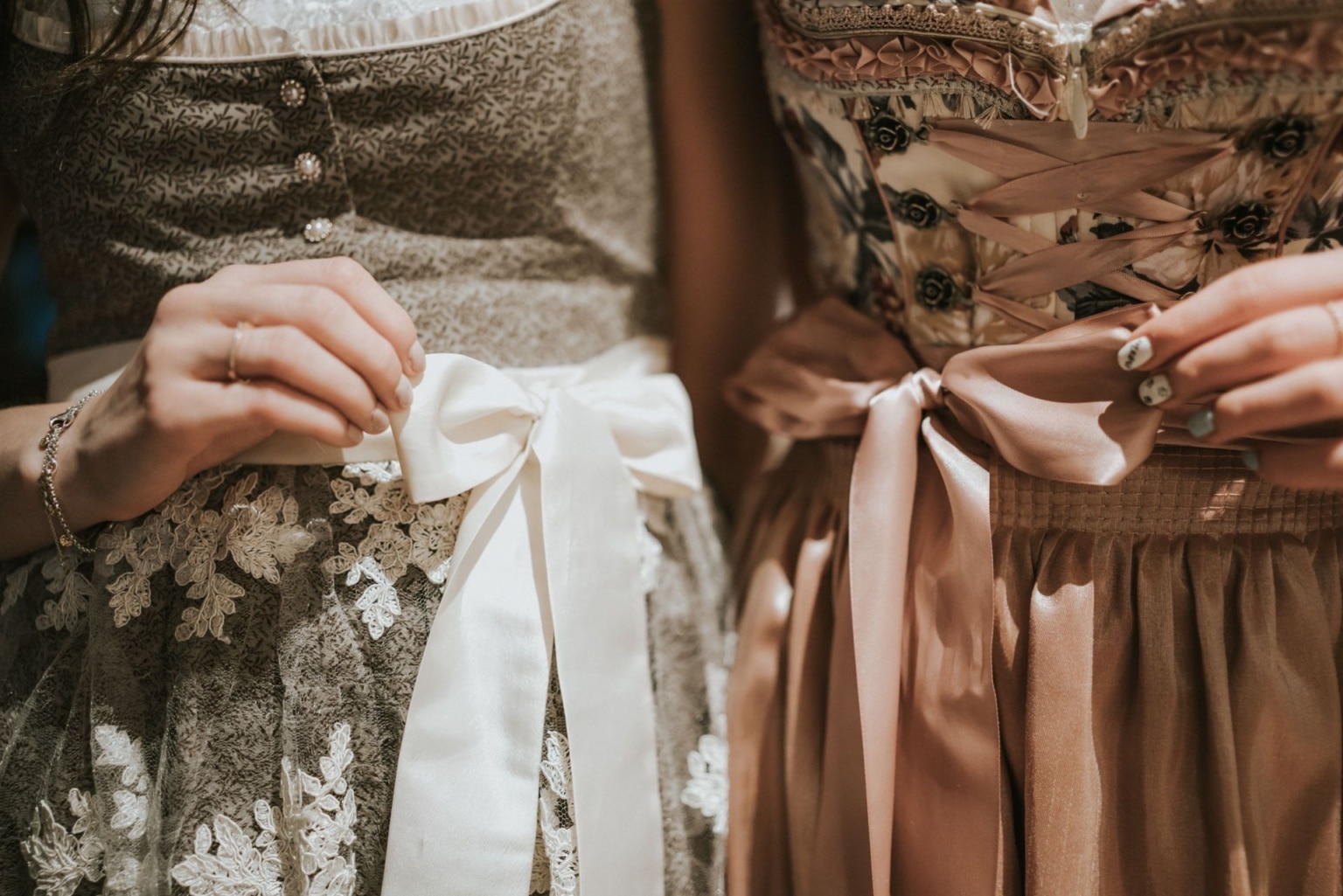 Zwei Frauen in traditioneller Kleidung mit Schleifen an ihren Kleidern