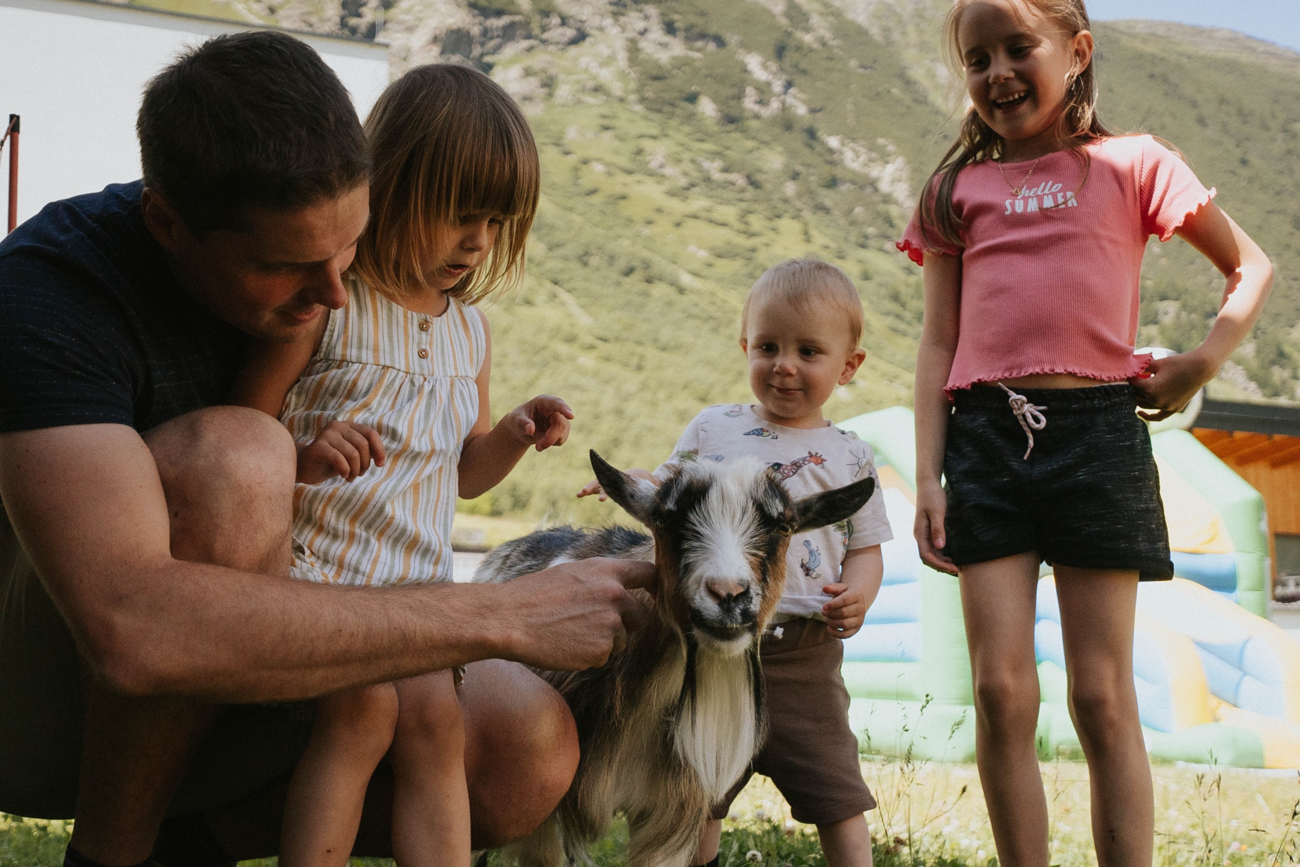 Familienaktivität mit Kindern und Ziegen in der Natur